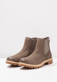 Braune Leder-Stiefeletten mit elastischen Seiteneinsätzen, runder Zehenpartie und robuster Gummisohle. Mit strukturiertem Obermaterial und Zugschlaufe für ein einfaches Ankleiden.