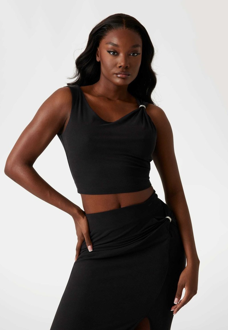Schwarzes Crop-Top mit weitem Rundhalsausschnitt und einer Schulterdrapierung, versehen mit einem silbernen Akzent. Glattes Material mit tailliertem Design und freiem Bauch.