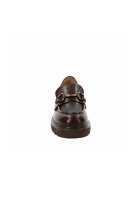 Mocasines de cuero marrón con punta redondeada, que presentan una correa ancha y acentos de hardware decorativos. Suela de goma gruesa y texturizada.