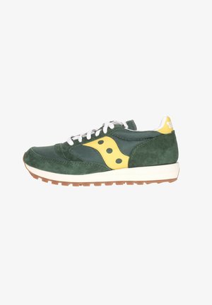 Sneaker verde in suede e mesh con accenti gialli. Presenta lacci bianchi e una suola marrone tessurizzata. Design a profilo basso.