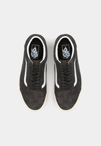 Sorte semskede sneakers med hvit side stripe, teksturert overdel, rund tå, sorte lisser og kremfarget gummisåle.