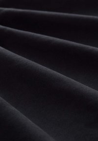 Tessuto nero con texture liscia, che mostra molteplici pieghe. Il materiale appare spesso e tessuto in modo uniforme, senza motivi o accenti visibili.