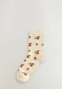 Beige cotton socks with brown squirrel and red mushroom patterns. Crew length with ribbed cuff; soft texture and fitted shape.