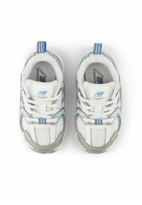 Un paio di scarpe da corsa New Balance bianche e azzurro chiaro viste dall'alto su uno sfondo bianco.