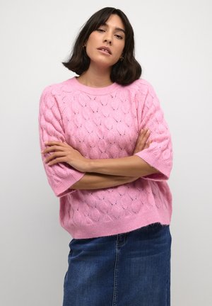 Pink knitted sweater with a textured, leaf-pattern design and short sleeves, paired with a denim skirt. Soft, lightweight fabric.
