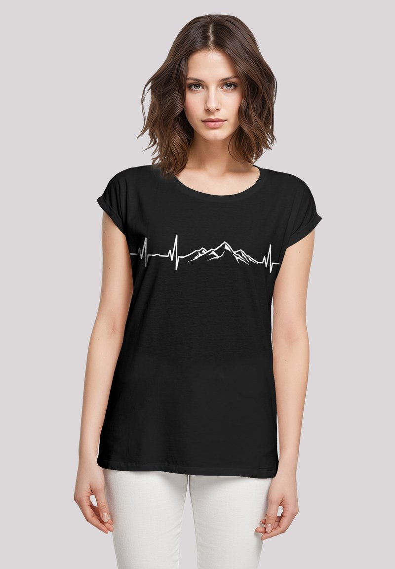 Zwarte t-shirt met een witte grafiek van een berg en een hartslaglijn. Korte mouwen, losse pasvorm, zachte stoftextuur.