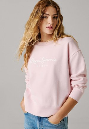 Roze sweatshirt met wit "Pepe Jeans" logo, geribbelde manchetten en zoom, zachte textuur, ronde halslijn, gecombineerd met lichtblauwe spijkerbroek.