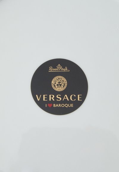 Λευκό πιάτο με μαύρο κυκλικό λογότυπο που περιλαμβάνει χρυσό κείμενο: «Rosen thal», «VERSACE» και «I ❤️ BAROQUE», μαζί με ένα σχέδιο Μέδουσας.