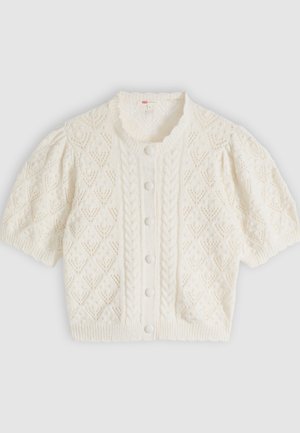 Λευκή πλεκτή ζακέτα με κοντά μανίκια, σχέδια διαμαντιού και καλωδίου, κουμπιά στο μπροστινό μέρος και στρογγυλή λαιμόκοψη με βολάν.