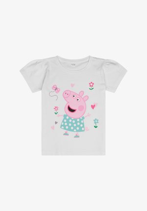 Camiseta blanca de manga corta con un personaje rosa que tiene una cara redonda, un vestido de lunares y acentos florales en rosa y verde.