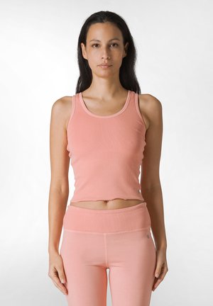 Light pink ribbed tank top with a scoop neckline, paired with matching high-waisted leggings. Material appears soft with a fitted shape.