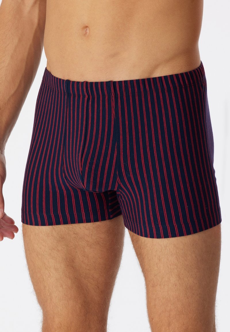 Pantaloni boxer blu navy con strisce verticali rosse, realizzati in un tessuto morbido, con cintura elastica e design aderente.