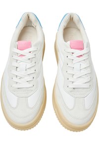 Baskets blanches en cuir et daim. Dotées d'une étiquette de marque rose, d'accents bleus sur le talon et d'une semelle en caoutchouc beige.