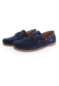 Marineblaue Wildlederschuhe mit Gummisohle, ausgestattet mit geflochtenen Schnürsenkeln, Nähakzenten und einem kleinen Logo an der Seite. Klassisches Design.