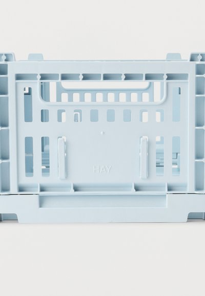 Στοίβα πλαστικών αποθηκευτικών κιβωτίων ανοιχτού γαλάζιου χρώματος με σχισμές αερισμού και την λέξη «HAY» διπλωμένη στην πλαϊνή επιφάνεια.