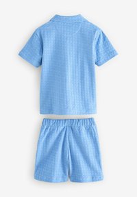 Ljusblå kortärmad skjorta och matchande shorts, med ett strukturerat mönster, mjukt tyg och elastisk midja för komfort.