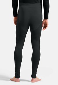 Black athletic leggings with a ribbed texture, fitted design, and seamless construction. Features a smooth waistband and tapered ankles.