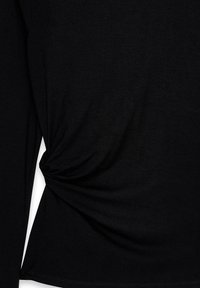 Juoda ilga rankovė viršutinė dalis, pagaminta iš sklandžios medžiagos. Turinti šoninio vyniojimo detales ir šiek tiek laisvą fasoną, su suapvalintu apdaila ir jokiais matomais aparatūros elementais.