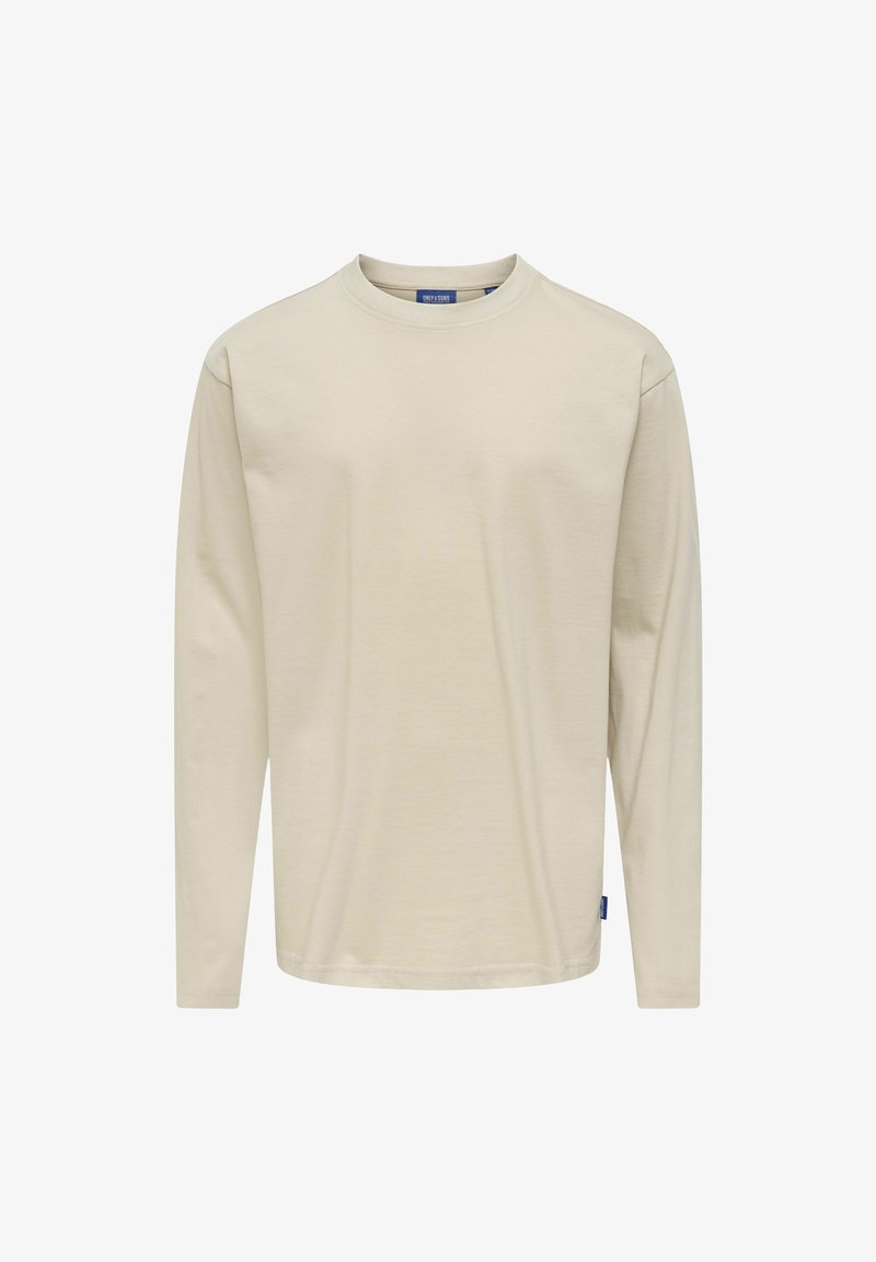 Beżowa bawełniana koszula z długim rękawem i okrągłym dekoltem. Posiada wszywane rękawy oraz małą niebieską metkę marki na dolnej stronie.