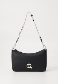 Borsa nera in pelle con texture, chiusura con zip, accessori in argento e un accento con faccina cartoon nella parte anteriore. Tracolla regolabile in due colori.
