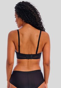 Conjunto de lencería negra con tirantes ajustables y cierre de gancho en la parte trasera. Material suave y elástico sin patrones.