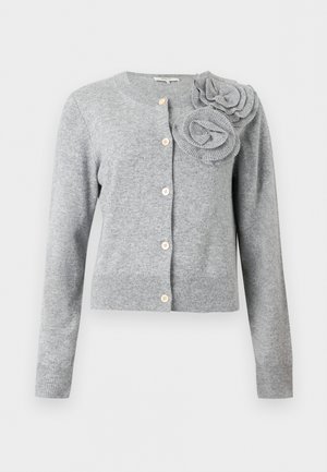 Šviesiai pilkas megsegamas kardiganas ilgomis rankovėmis ir dvi didelės audinio gėlių dekoracijos ant kairiojo peties.