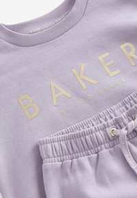 Svetlo fialová mikina s zlatým logom "BAKER", ribovaným výstrihom a elastickým pásom s detailom šnúrky.