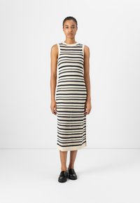 Robe sans manches en tricot présentant des rayures horizontales noires et crème alternées avec des motifs ajourés, longueur genou et ourlet côtelé.