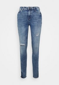 Jeans skinny em denim azul médio com um design desgastado, incluindo rasgos nos joelhos e zíperes nas bainhas para um ajuste ajustável.