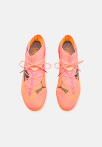 Rosa Sportschuhe mit einer gestrickten Textur, einem hohen Design und kontrastierenden schwarzen Zickzack-Akzenten. Sie verfügen über Schnürsenkel und einen gepolsterten Schaft.
