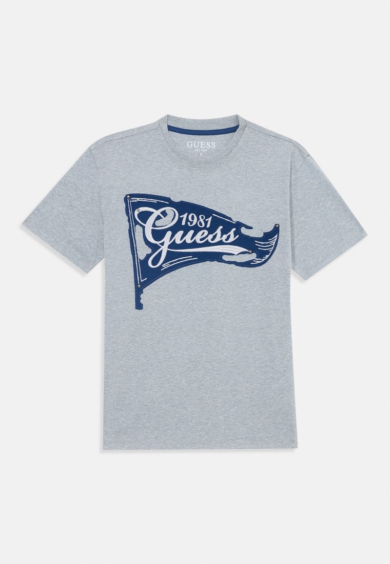 Graues Baumwoll-T-Shirt mit kurzen Ärmeln, mit einem dunkelblauen Grafikdesign eines Flags und dem Text "Guess 1981". Klassischer Rundhalsausschnitt.
