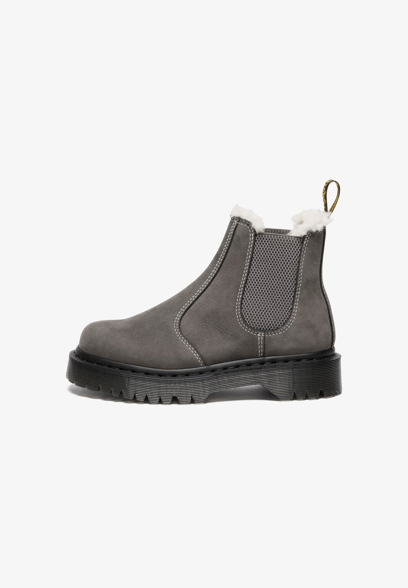 Botte Chelsea en daim gris avec une semelle épaisse noire, une bande élastique sur le côté, une doublure en fourrure blanche au col et une languette au talon.