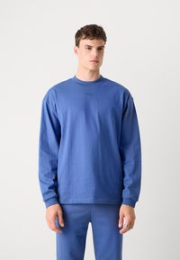 Blue cotton long-sleeve T-shirt with a round neckline, featuring a subtle logo at the chest and a relaxed fit. Soft texture and even color.