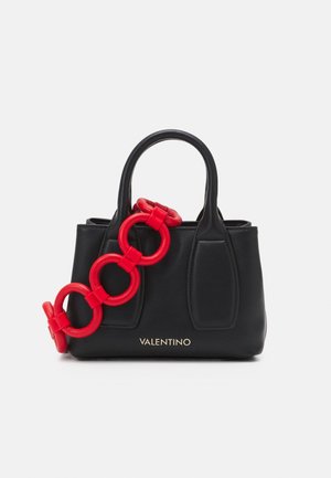 Czarna skórzana torebka z krótkimi uchwytami, z dużym czerwonym akcentem w postaci łańcucha i złotym logo "VALENTINO" na dole.