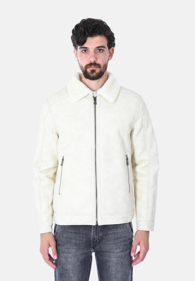 Giacca beige foderata in shearling con chiusura a zip, due tasche laterali con zip e un ampio colletto. Texture liscia con sottili dettagli di cucitura.