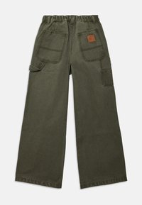 Pantalon cargo à jambes larges en coton vert olive, avec une taille élastique, plusieurs poches et un écusson logo en cuir marron.