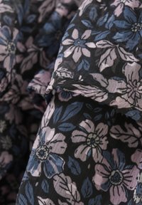 Blumenstoff in Schwarz, mit rosa und blauen Blumen sowie grünen Akzenten. Leichtes, strukturiertes Material mit sanftem Fall.