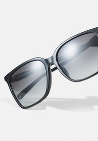 Large sunglasses with a black frame and gradient gray lenses. The design features smooth edges and slim temples for a modern look.