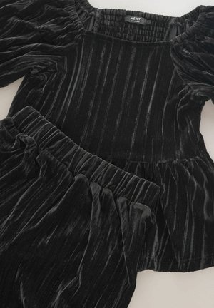 Fekete bársony két részes szett, összegyűrt dekoltázzsal és puffos ujjakkal. A blúz peplum fazonú, derékrésze rugalmas.