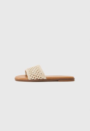 Beige vevde sandaler med åpen tå, med et heklet design på overdelen og en flat, brun syntetisk såle. Minimalistisk estetikk.