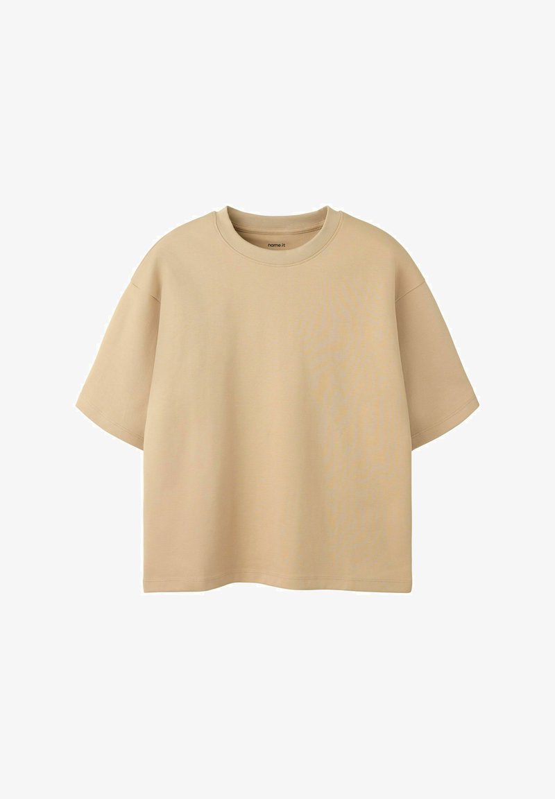 T-shirt beige oversize à manches courtes avec col rond, présenté sur fond blanc.
