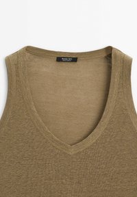 Olivgroen tanktop met een V-hals, gemaakt van een zachte stof. Heeft een eenvoudige, gladde textuur en een genaaide label aan de binnenkant van de halslijn.
