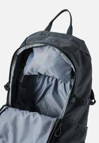 Ciemnoszary plecak z dużą, otwartą główną komorą, pokazujący jasnoszarą wyściółkę wnętrza oraz wyściełaną kieszeń na laptopa w środku.