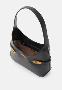 Sac à main en cuir noir à forme incurvée, avec des accents métalliques dorés et une poche intérieure zippée. Texture lisse, bandoulière unique.