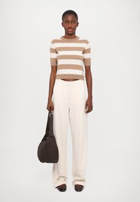 Brown and beige striped cropped sweater, cream wide-leg trousers, brown handbag, and dark shoes. Smooth textures and simple design.