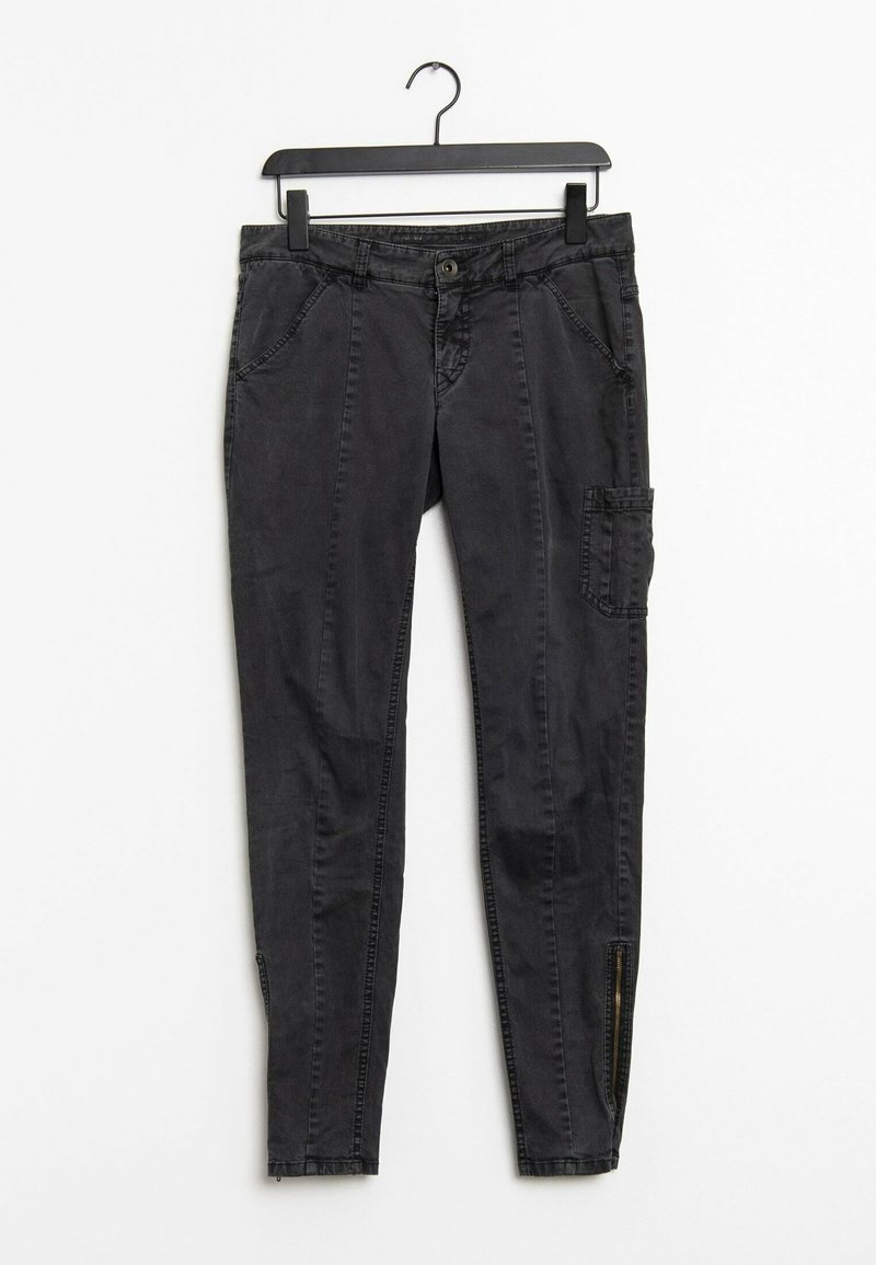 Pantalon noir slim fit avec poches avant, une poche cargo latérale et des fermetures éclair aux chevilles, suspendu sur un cintre noir sur fond blanc.