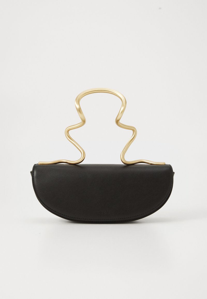 Bolsa de couro preta em forma de meia-lua com uma alça de metal dourada ondulada e única, colocada sobre um fundo branco liso.