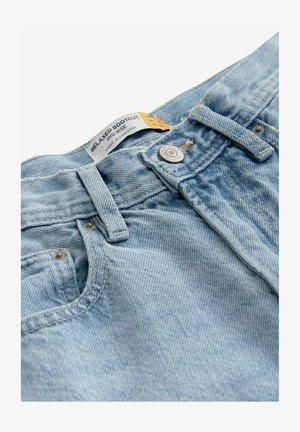 Jean en denim bleu clair avec une coupe bootcut décontractée, taille mi-haute, fermeture à bouton en métal, et étiquette indiquant "BOOTCUT DÉCONTRACTÉ".