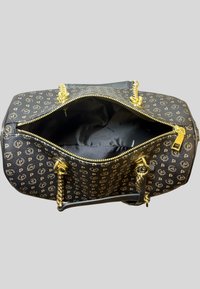 Borsa designer nera con manici a catena dorata, motivo beige con logo ripetuto, e cerniera aperta che mostra un interno vuoto in tessuto nero.