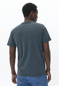 T-shirt à manches courtes gris foncé, fabriqué en tissu texturé, col rond, avec une coupe décontractée et un subtil motif rayé dans le dos.